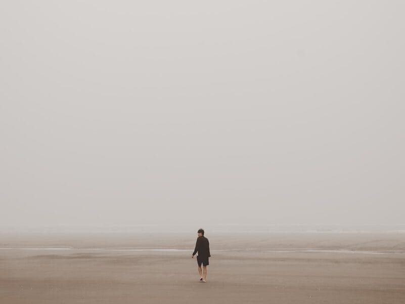 man standing on brown sand